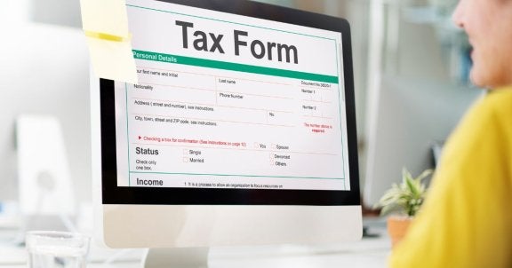 tax season scams, safety during taxes, woman filling out tax form