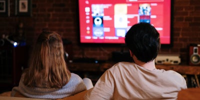 couple sitting on a couch watching tv