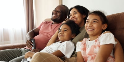 happy family sitting on a couch and watching tv