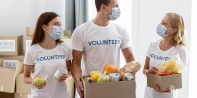 volunteers with masks collect food for donations