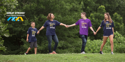four people walking hand in hand with "I stride until it's done" on their shirts