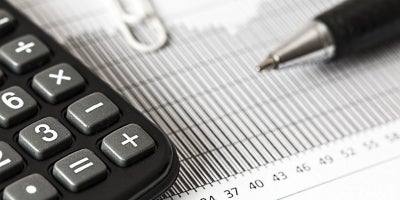 photo of paperwork with a calculator and pen