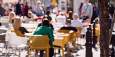 blurry photo of people eating at patio tables 