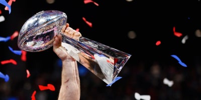 photo of hand holding super bowl lombardi trophy in triumph