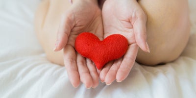 hands together holding fabric heart