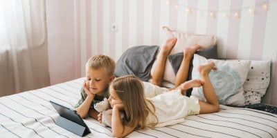 photo of two children sharing and watching a tablet