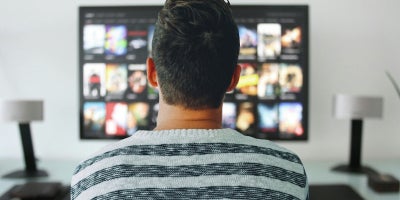 back view of man watching tv 
