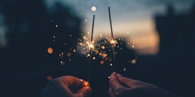 photo at night with two hands holding sparklers