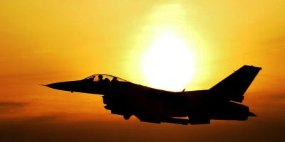photo of jet with sunset behind