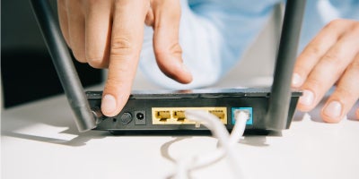 buckeye blog, wifi 101, how to troubleshoot wifi, man pressing power button on wifi router