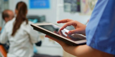 buckeye blog, health care industry technology, technology in healthcare, nurse on tablet and patient in background