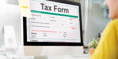 tax season scams, safety during taxes, woman filling out tax form