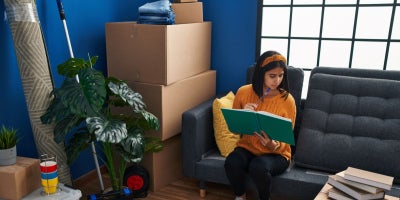 college apartment checklist, woman packing in room