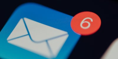 Close-up of email logo on cellular device displaying 6 notifications in the upper right corner