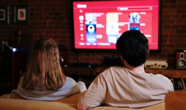 couple sitting on a couch watching tv