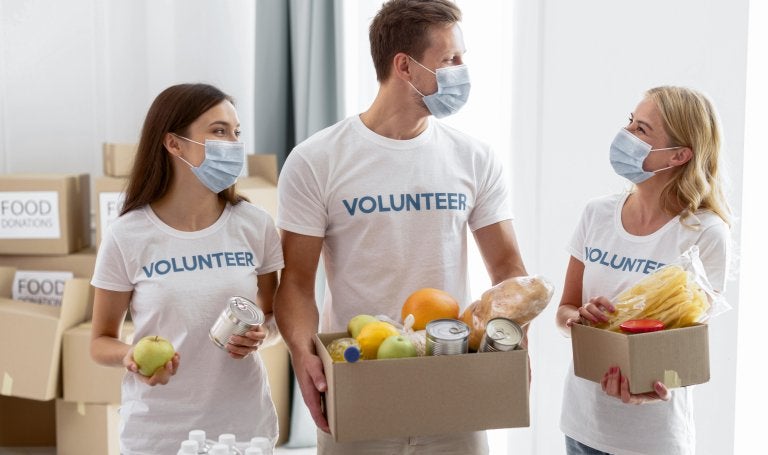 volunteers with masks collect food for donations