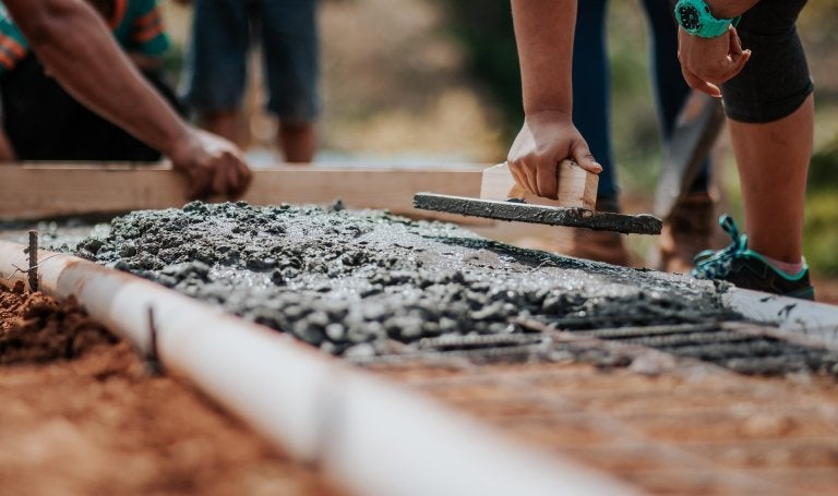 group of people laying concrete foundation