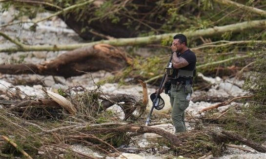 A Sheriff's deputy pauses while combing through the banks of the Guadalupe River near Camp Mystic on July 5 in Hunt, Texas, after a flash flood swept through the area.