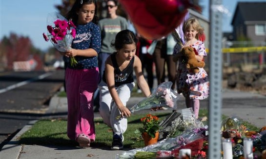 Flowers are placed beside a sign at Silver Rail Elementary School in Bend, Ore., Oct. 16 a day after a deadly shooting.