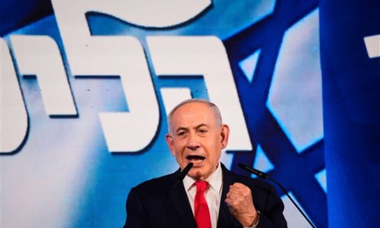 Gadi Eisenkot, leader of the Yashar ("Straight") party, waves an Israeli flag onstage following the release of the first exit poll results in Israel's general election in Tel Aviv, Israel, on Oct. 28.