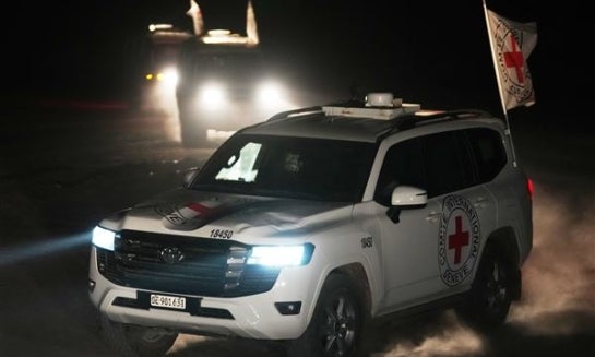 Red Cross vehicles carrying the bodies of three people believed to be deceased hostages handed over by Hamas make their way toward the border crossing with Israel, to be transferred to Israeli authorities, in Deir al-Balah, central Gaza Strip, Sunday.