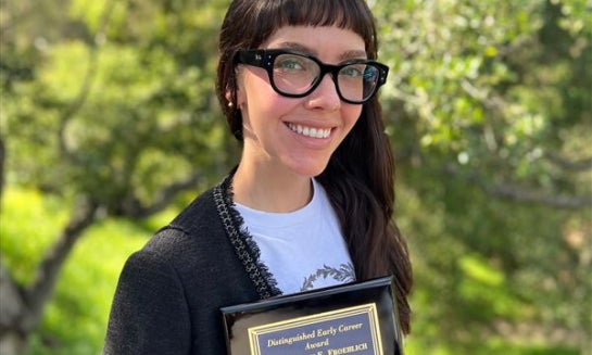 This photo taken with a smart phone and provided by Halley Froehlich shows Froehlich holding a U.S. Aquaculture Society award in Santa Barbara, Calif., on Feb. 27.