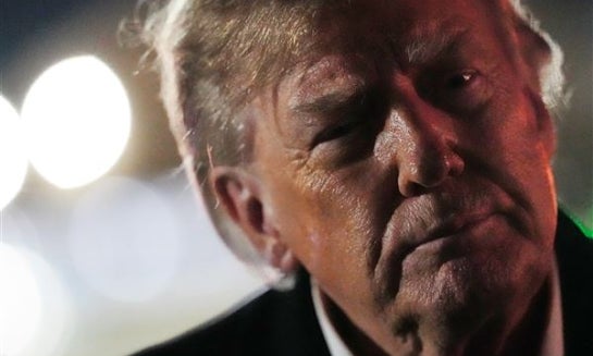 President Donald Trump listens as Georgia U.S. Senate candidate Rep. Mike Collins, R-Ga., speaks at a campaign rally at Dalton Municipal Airport on Oct. 16 in Dalton, Ga.