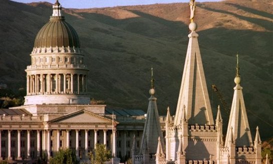 The sun sets on Utah's Capitol, left, and the angel-topped spire of the Mormon Temple in 1999 in Salt Lake City.