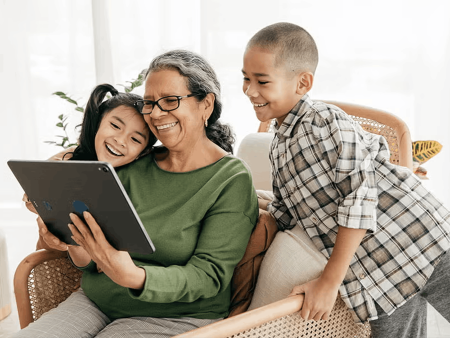 Two kids and grandma looking at tablet