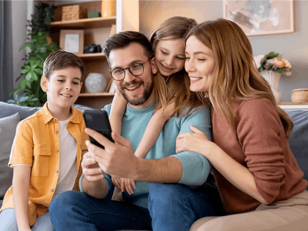 Family sitting on couch looking at a phone