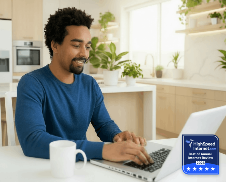 man-sitting-in-kitchen-using-laptop_highspeed-internet-best-of-annual-internet-review-2026-badge