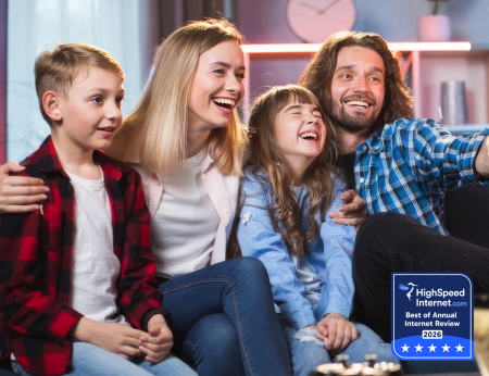 smiling family in living room watching tv