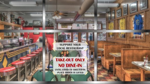 restaurant with sign on the door that says due to pandemic they are doing take-out only