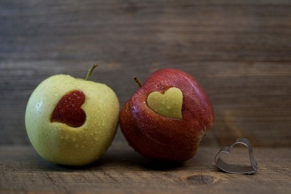 photo of green apple with red apple heart and red apple with green apple heart