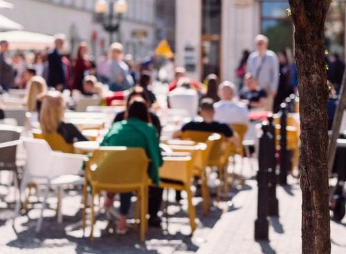 blurry photo of people eating at patio tables 