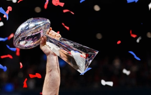 photo of hand holding super bowl lombardi trophy in triumph