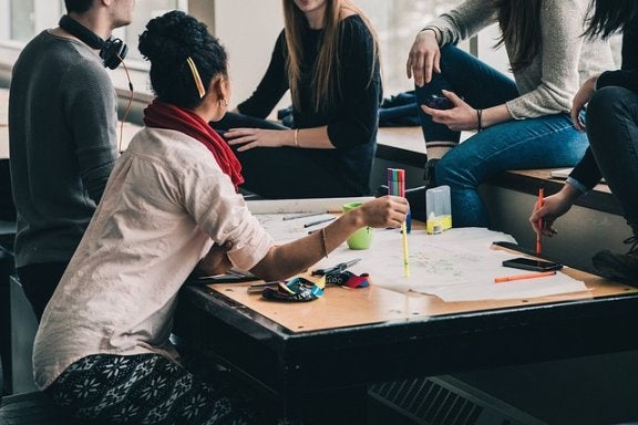 group of students gathered around a table studying