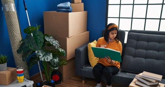 college apartment checklist, woman packing in room