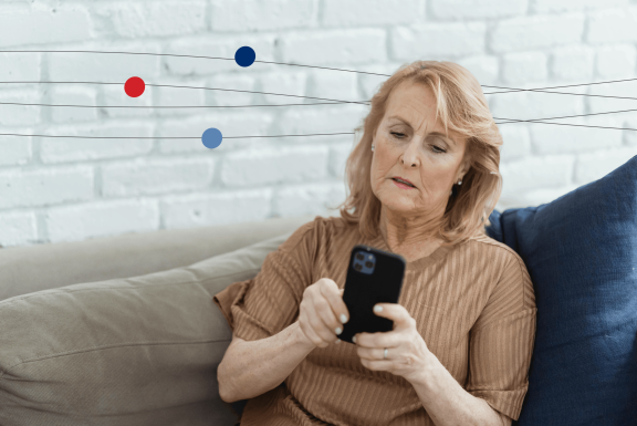 Woman sitting on couch at home while on cell phone with a frustrated look 
