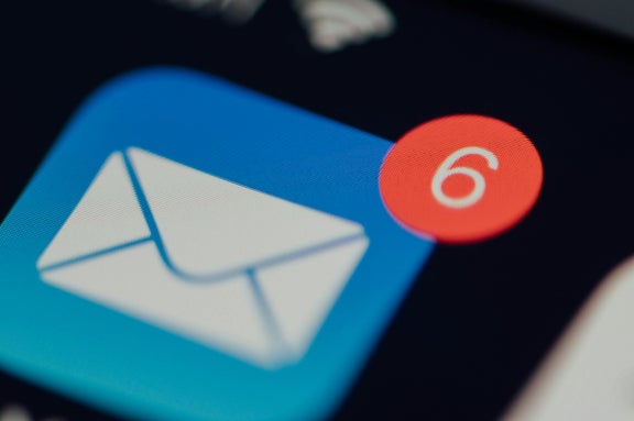 Close-up of email logo on cellular device displaying 6 notifications in the upper right corner