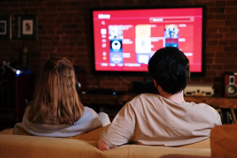 couple sitting on a couch watching tv