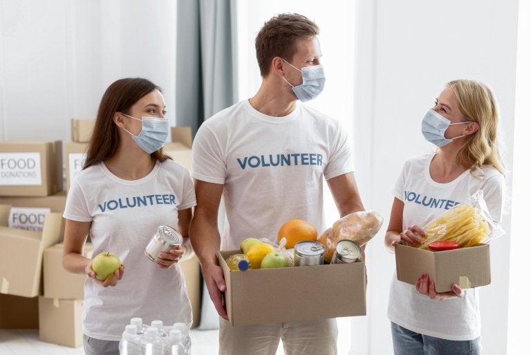 volunteers with masks collect food for donations
