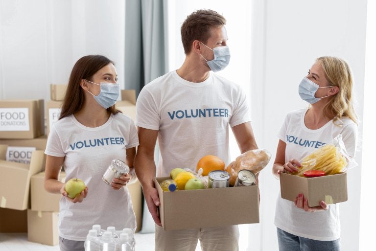 volunteers with masks collect food for donations