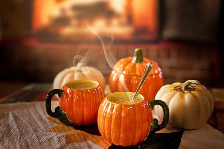 image of hot bevarages in pumpkin shaped mugs surrounded by mini pumpkins
