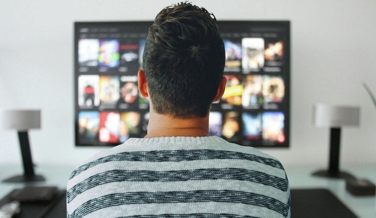 back view of man watching tv 