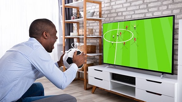 Man watching soccer game holding a ball, live sports streaming, sports tv streaming