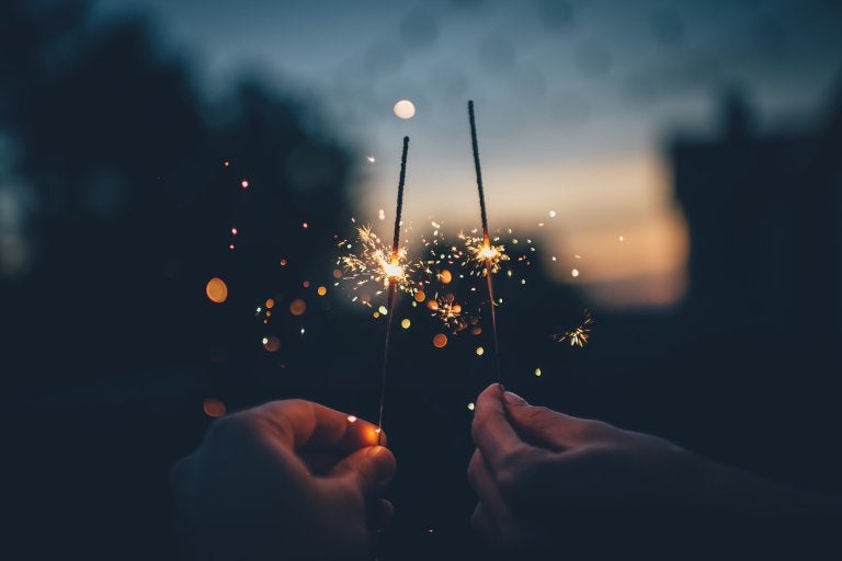 photo at night with two hands holding sparklers