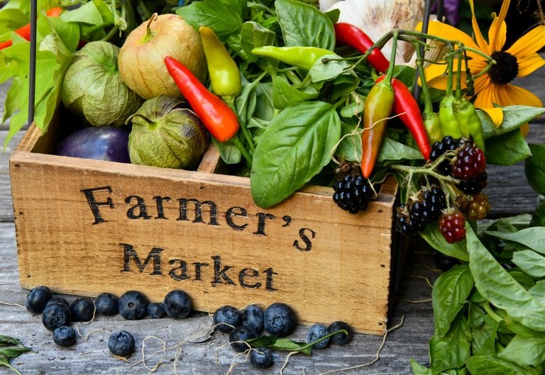 wooden box labeled farmer's market filled with fresh veggies