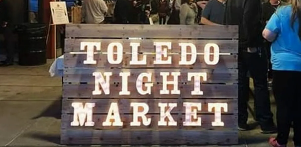 photo of wooden sign with words toledo night market in lights