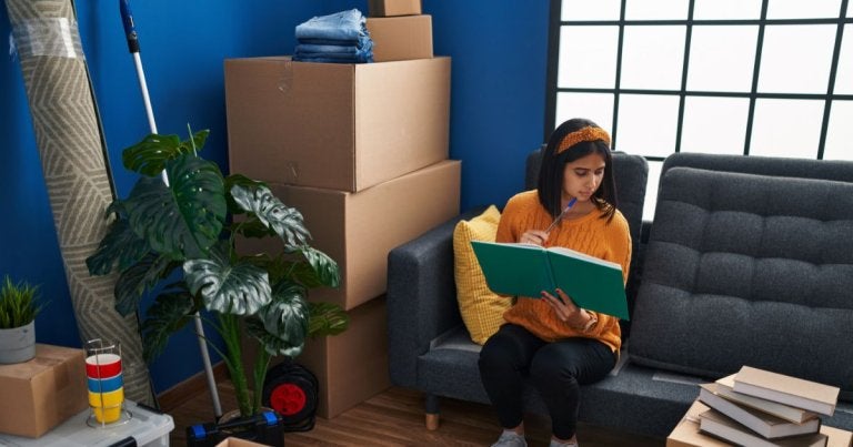college apartment checklist, woman packing in room